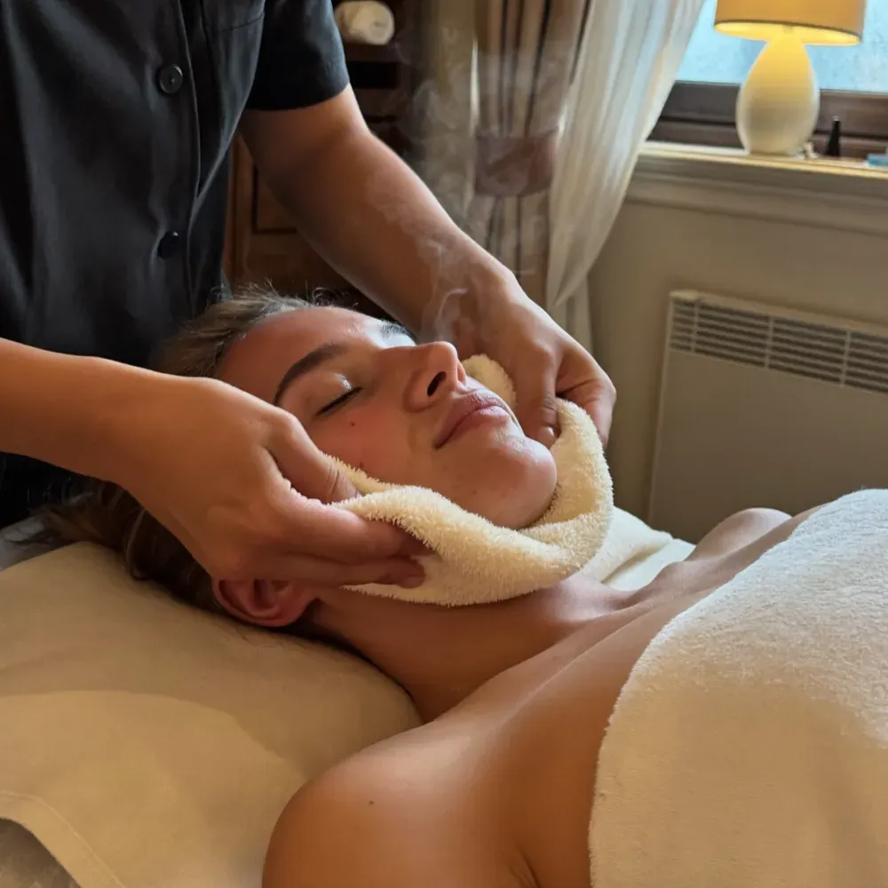 A warm towel pressed gently over a client's face during a facial